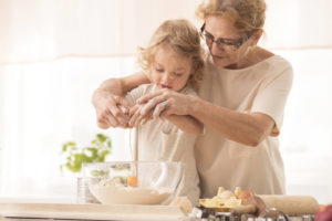 nanny teaching child to break an egg